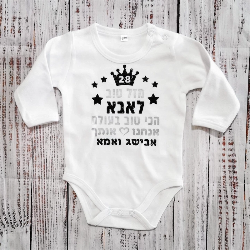 בגד גוף לתינוק "מזל טוב לאבא הכי טוב בעולם", לבן כיתוב כסוף ושחור מנצנץ